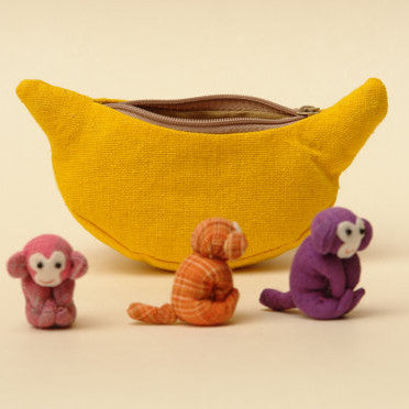 Three cheeky fun loving monkeys who happily live in their banana purse home