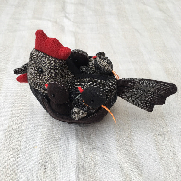 "Cluck Cluck" marvellously plump Mother hen here with four small chicks safely nestled under her wings.